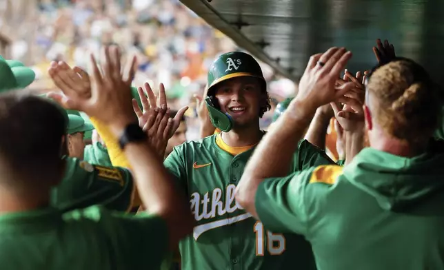 Athletics' Nick Kurtz celebrates in the dugout after scoring during the second inning of a baseball game against the Detroit Tigers Wednesday, Aug. 27, 2025, in West Sacramento, Calif. (AP Photo/Sergio Estrada)