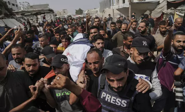 Palestinians carry the body of Al Jazeera correspondent Anas al-Sharif, who, along with other journalists, was killed in an Israeli airstrike, during his funeral outside Gaza City's Shifa hospital complex, Monday, Aug. 11, 2025. (AP Photo/Jehad Alshrafi)