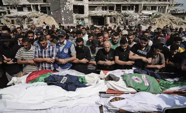 Palestinians pray over the bodies of journalists, including Al Jazeera correspondents Anas al-Sharif and Mohamed Qreiqeh, who were killed in an Israeli airstrike, during their funeral outside Gaza City's Shifa hospital complex, Monday, Aug. 11, 2025. (AP Photo/Jehad Alshrafi)