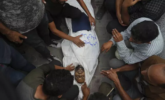 Colleagues and friends mourn over the body Al Jazeera correspondent Mohamed Qureiqa who was killed with his colleague Anas al-Sharif and other journalists by an Israeli airstrike, at Shifa Hospital in Gaza City Monday, Aug. 11, 2025. (AP Photo/Jehad Alshrafi)
