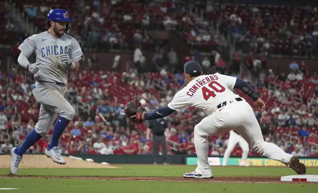 Chicago Cubs' Dansby Swanson, left, reaches base on a throwing error by St. Louis Cardinals third baseman Nolan Gorman as first baseman Willson Contreras (40) reaches for the ball during the fifth inning of a baseball game Sunday, Aug. 10, 2025, in St. Louis. (AP Photo/Jeff Roberson)