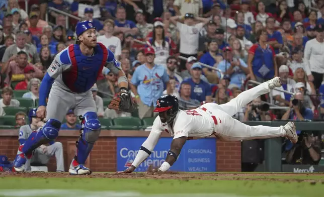 St. Louis Cardinals' Jordan Walker, right, scores past Chicago Cubs catcher Carson Kelly during the seventh inning of a baseball game Sunday, Aug. 10, 2025, in St. Louis. (AP Photo/Jeff Roberson)