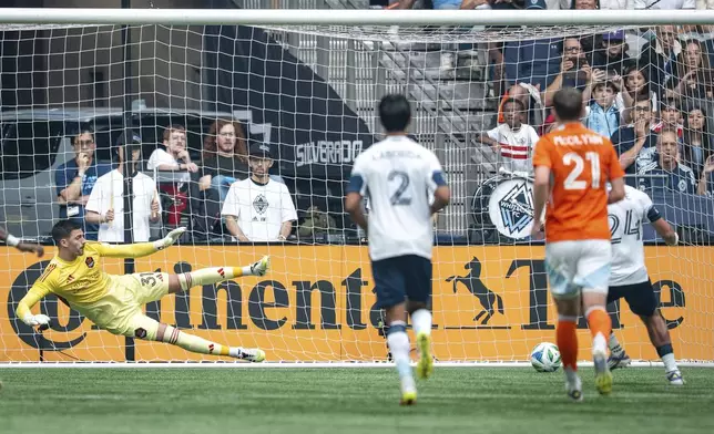 Vancouver Whitecaps' Brian White, right, scores on Houston Dynamo goalkeeper Jonathan Bond (31) during the first half of an MLS soccer match in Vancouver, British Columbia, Sunday, Aug. 17, 2025. (Ethan Cairns/The Canadian Press via AP)