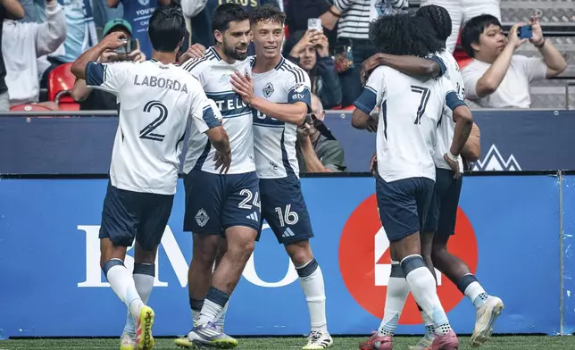Vancouver Whitecaps' Brian White celebrates his goal against the Houston Dynamo with Mathias Laborda (2), Sebastian Berhalter and Jayden Nelson (7) during the first half of an MLS soccer match in Vancouver, British Columbia, Sunday, Aug. 17, 2025. (Ethan Cairns/The Canadian Press via AP)