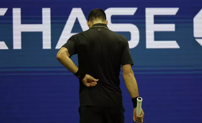 Novak Djokovic, of Serbia, holds his back against Cameron Norrie, of Great Britain, during the third round of the U.S . Open tennis championships, Friday, Aug. 29, 2025, in New York. (AP Photo/Adam Hunger)