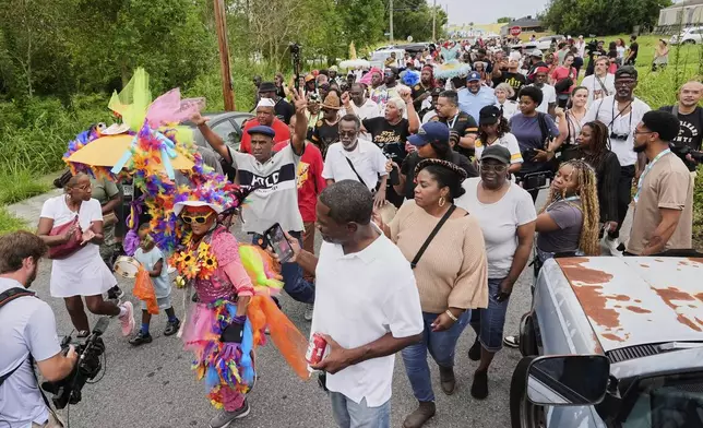People form a second line parade during an event to commemorate the 20th anniversary of Hurricane Katrina, in the Lower Ninth Ward of New Orleans, Friday, Aug. 29, 2025. (AP Photo/Alex Brandon)