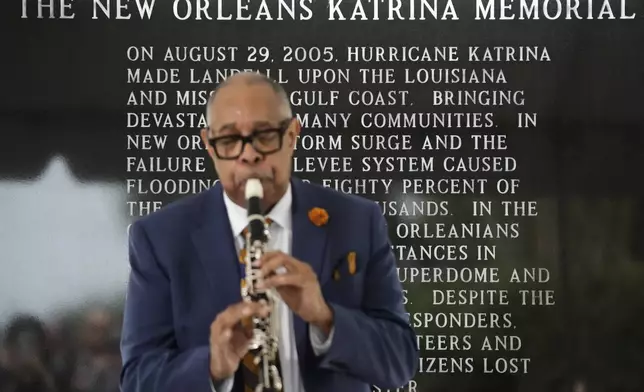 The New Orleans Katrina Memorial stands behind Dr. Michael White during a wreath laying event to commemorate the 20th anniversary of Hurricane Katrina in Charity Hospital Cemetery in New Orleans, Friday, Aug. 29, 2025. (AP Photo/Gerald Herbert)