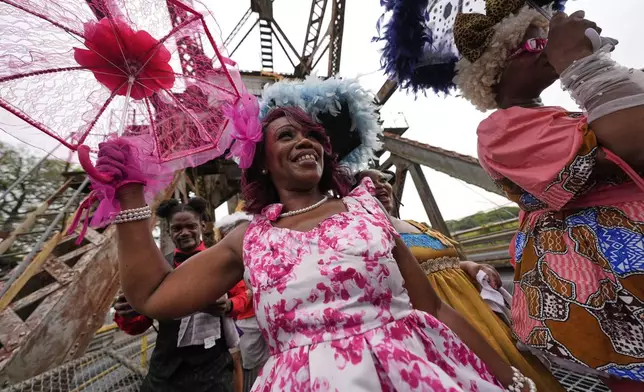 Members of the Original New Orleans Baby Dolls march in a second line parade to commemorate the 20th anniversary of Hurricane Katrina, in the Lower Ninth Ward of New Orleans, Friday, Aug. 29, 2025. (AP Photo/Gerald Herbert)