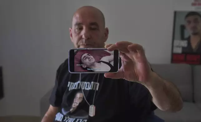 Ofir Braslavski shows a video from militant group Palestinian Islamic Jihad, published last week of his son gaunt and emaciated in captivity in Gaza, in Almon, an Israeli settlement in the West Bank, Monday, Aug. 04, 2025. (AP Photo/Ohad Zwigenberg)