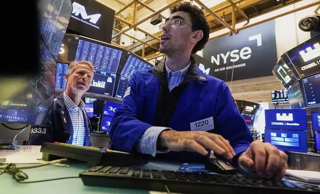 Specialist Alex Weitzman, right, works at his post on the floor of the New York Stock Exchange, Friday, Aug. 15, 2025. (AP Photo/Richard Drew)