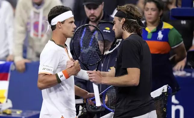 Daniel Altmaier, left, of Germany, is congratulated by Stefanos Tsitsipas, of Greece, after defeating him during the second round of the U.S. Open tennis championships, Thursday, Aug. 28, 2025, in New York. (AP Photo/Frank Franklin II)