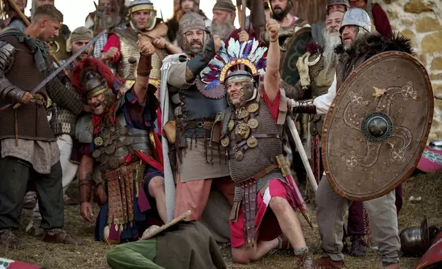 Members of historical groups wearing Roman soldiers and Dacian warriors outfits, reenact a battle in Poiana, Romania, Saturday, July 12, 2025, during the Getodava historical reenactment festival. (AP Photo/Vadim Ghirda)