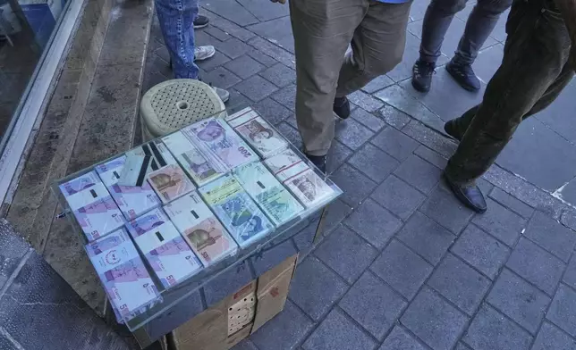 Iranian and foreign banknotes are displayed by a street money exchanger at Ferdowsi square, Tehran's go-to venue for foreign currency exchange, in downtown Tehran, Iran, Thursday, Aug. 28, 2025. (AP Photo/Vahid Salemi)