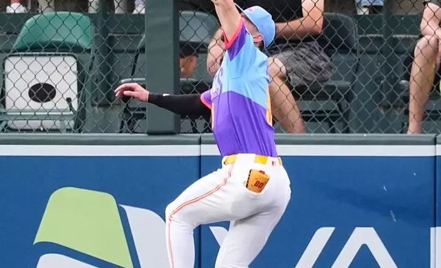 Colorado Rockies center fielder Brenton Doyle pulls in a fly ball off the bat of Arizona Diamondbacks' Ketel Marte in the first inning of a baseball game Friday, Aug. 15, 2025, in Denver. (AP Photo/David Zalubowski)