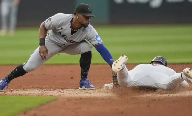 Cleveland Guardians' Brayan Rocchio, right, slides under the tag of Miami Marlins shortstop Otto Lopez, left, to steal second base in the second inning of a baseball game in Cleveland, Tuesday, Aug. 12, 2025. (AP Photo/Sue Ogrocki)