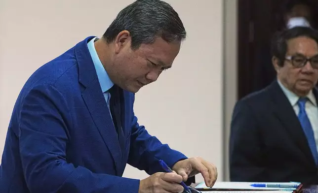 Cambodian Prime Minister Hun Manet registers before entering the session on the draft law on amending the law on nationality in the National Assembly in Phnom Penh Cambodia, Monday, Aug. 25, 2025. (AP Photo/Heng Sinith)