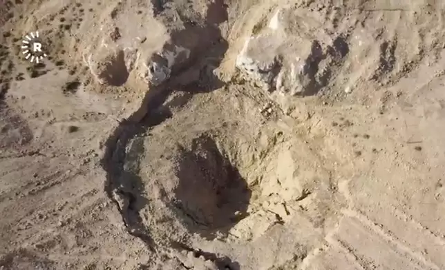 In this image taken from video provided by Rudaw TV, an aerial view shows a sinkhole at the Khasfa site near the northern Iraqi city of Mosul, where authorities have begun excavating a mass grave believed to contain thousands of victims of the Islamic State (IS) Mosul, Iraq, Sunday, Aug. 17, 2025. (Rudaw TV via AP)