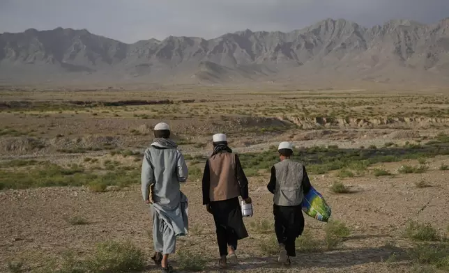 Afghan boys walk back to the Abdullah Ibn-Masoud religious school where they live after collecting food aid from nearby villages in the outskirts of Kabul, Afghanistan, Monday, May 26, 2025. (AP Photo/Ebrahim Noroozi)