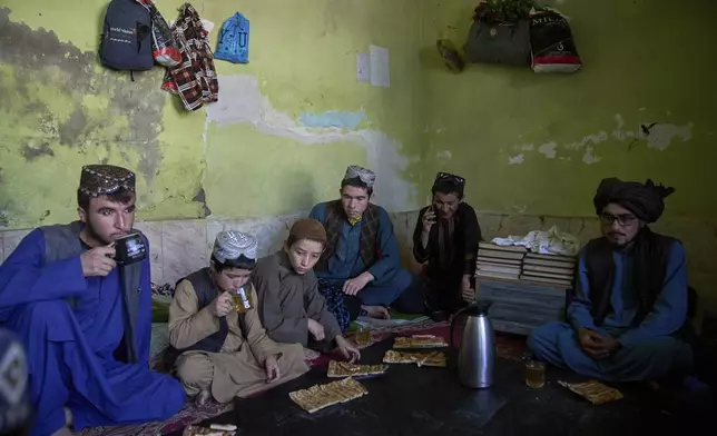Afghan boys living at the Imam al-Tirmidhi religious school eat bread and tea for breakfast in Kabul, Afghanistan, Wednesday, June 11, 2025. (AP Photo/Ebrahim Noroozi)