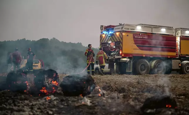 This photo, provided by the Securite Civile on Thursday Aug. 7, 2025, shows firemen from the Securite Civile working at the wildfire near Saint-Laurent-de-la-Cabrerisse, southern France, Wednesday, Aug. 6, 2025. (Securite Civile via AP)