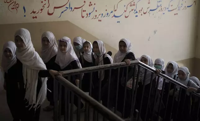 FILE - Girls walk upstairs as they enter a school before class in Kabul, Afghanistan, Sunday, Sept. 12, 2021. (AP Photo/Felipe Dana, File)