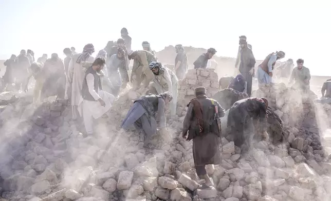 FILE - Afghan volunteers clean up rubble after an earthquake in Zenda Jan district in Herat province, western Afghanistan, Wednesday, Oct. 11, 2023. (AP Photo/Ebrahim Noroozi, File)