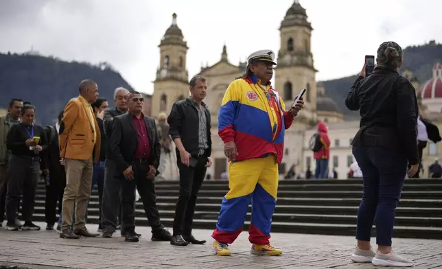 People line up outside Congress to pay their last respects to presidential hopeful and opposition Sen. Miguel Uribe, who died from wounds suffered when he was shot at a political rally, in Bogota, Colombia, Tuesday, Aug. 12, 2025. (AP Photo/Fernando Vergara)