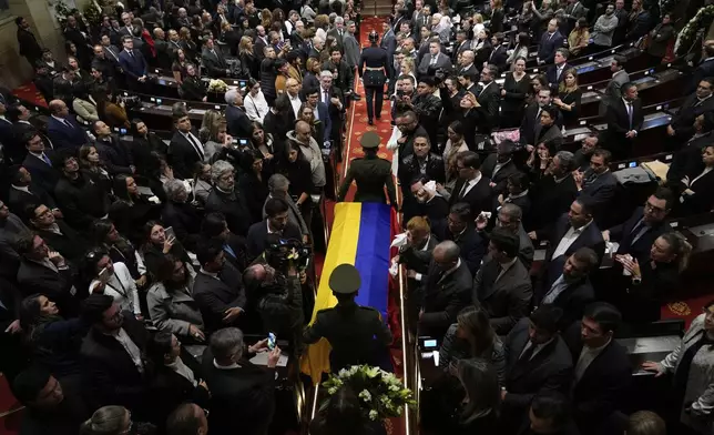 The coffin of presidential hopeful and opposition Sen. Miguel Uribe, who died from wounds suffered when he was shot at a political rally, is carried into Congress in Bogota, Colombia, Monday, Aug. 11, 2025. (AP Photo/Fernando Vergara)
