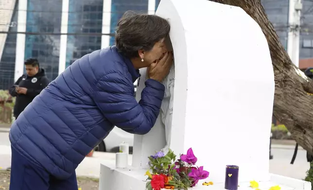 A woman prays at an altar built at the site where opposition Sen. and presidential hopeful Miguel Uribe was shot during a political rally, after the announcement of his death, in Bogota, Colombia, Monday, Aug. 11, 2025. (AP Photo/John Wilson Vizcaino)