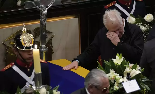 Miguel Uribe, the father of presidential hopeful and opposition Sen. Miguel Uribe, cries beside his son's coffin, at Congress in Bogota, Colombia, Monday, Aug. 11, 2025, after the senator died from wounds suffered when he was shot at a political rally. (AP Photo/Fernando Vergara)