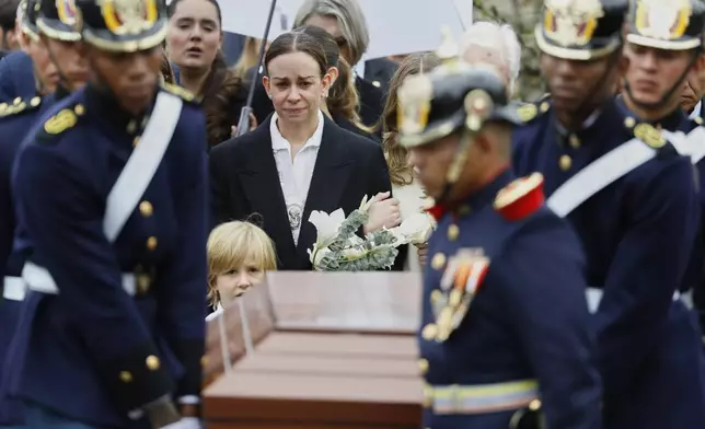Maria Claudia Tarazona, wife of presidential hopeful and opposition Sen. Miguel Uribe, who died from wounds suffered when he was shot at a political rally, walks behind his coffin at Central Cemetery in Bogota, Colombia, Wednesday, Aug. 13, 2025.(AP Photo/John Vizcaino)