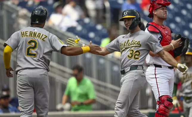 Athletics' Darell Hernaiz (2) congratulates Colby Thomas (32) for driving him in on a two-run home run during the second inning of a baseball game against the Washington Nationals, Thursday, Aug. 7, 2025, in Washington. (AP Photo/John McDonnell)