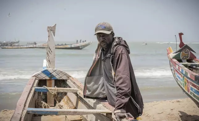 Famara Nudure, a fisherman for more than 40 years, leans against his boat in Gunjur, Gambia, after a day of work, on March 23, 2025. (AP Photo/Grace Ekpu)