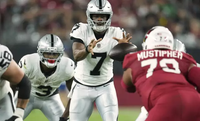 Las Vegas Raiders quarterback Geno Smith (7) takes the snap against the Arizona Cardinals during the first half of an NFL preseason football game, Saturday, Aug. 23, 2025, in Glendale. (AP Photo/Ross D. Franklin)