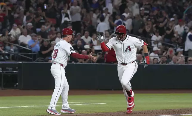 Arizona Diamondbacks' Tyler Locklear, right, celebrates his home run against the San Diego Padres with Diamondbacks third base coach Shaun Larkin during the third inning of a baseball game Monday, Aug. 4, 2025, in Phoenix. (AP Photo/Ross D. Franklin)