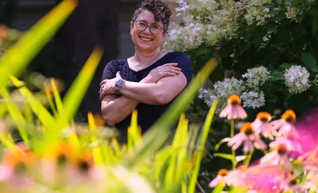 Ziva Mann, mother of a transgender child and member of a welcoming synagogue, poses in her garden, Wednesday, Aug. 13, 2025, in Newton, Mass. (AP Photo/Charles Krupa)