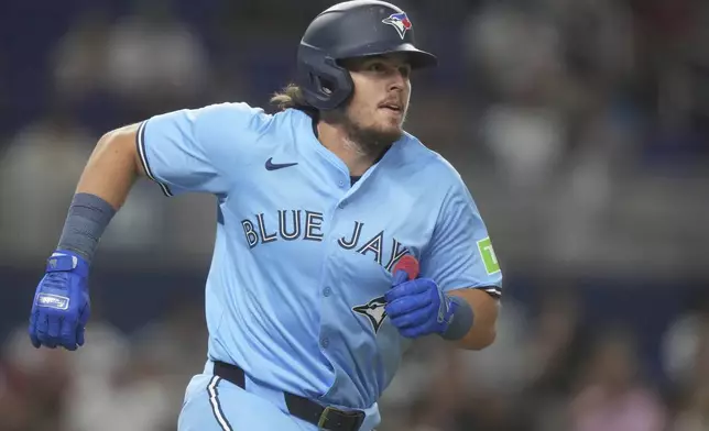 Toronto Blue Jays' Addison Barger runs after hitting a base hit during the third inning of a baseball game against the Miami Marlins, Friday, Aug. 22, 2025, in Miami. (AP Photo/Marta Lavandier)