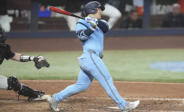 Toronto Blue Jays' Daulton Varsho hits a two-run home run during the sixth inning of a baseball game against the Miami Marlins, Friday, Aug. 22, 2025, in Miami. (AP Photo/Marta Lavandier)