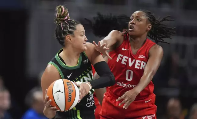 Minnesota Lynx's Kayla McBride (21) is defended by Indiana Fever's Kelsey Mitchell (0) during the second half of a WNBA basketball game, Friday, Aug. 22, 2025, in Indianapolis. (AP Photo/Darron Cummings)
