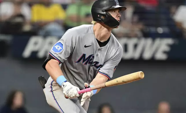 Miami Marlins' Kyle Stowers watches his ball after hitting an RBI single during the sixth inning of a baseball game against the Cleveland Guardians, Wednesday, Aug. 13, 2025, in Cleveland. (AP Photo/David Dermer)