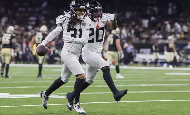 Jacksonville Jaguars cornerback Keni-H Lovely (31) celebrates a pass interception against the New Orleans Saints with safety Daniel Thomas (20) in the second half of an NFL preseason football game in New Orleans, Sunday, Aug. 17, 2025. (AP Photo/Butch Dill)