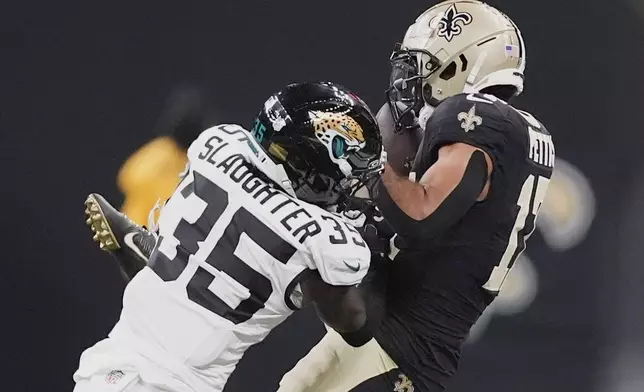 New Orleans Saints wide receiver Dante Pettis makes a reception against Jacksonville Jaguars cornerback Doneiko Slaughter (35) in the second half of an NFL preseason football game in New Orleans, Sunday, Aug. 17, 2025. (AP Photo/Gerald Herbert)