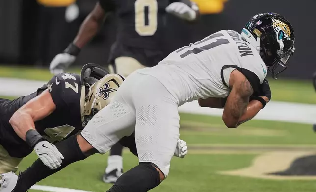 Jacksonville Jaguars wide receiver Parker Washington (11) makes a reception for a touchdown on a 7-yard pass play against New Orleans Saints linebacker Danny Stutsman (47) in the first half of an NFL preseason football game in New Orleans, Sunday, Aug. 17, 2025. (AP Photo/Gerald Herbert)