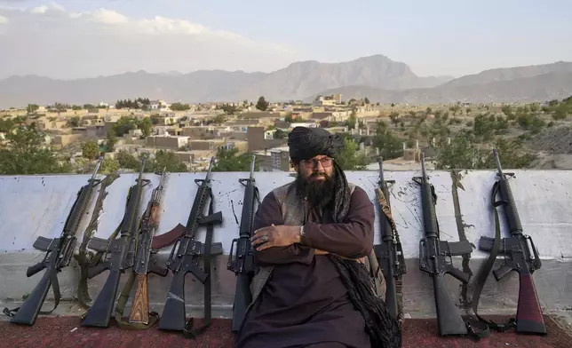 FILE - A Taliban fighter sits among the rifles on Nadir Khan hill in Kabul, Afghanistan, Tuesday, June 10, 2025. (AP Photo/Ebrahim Noroozi, File)
