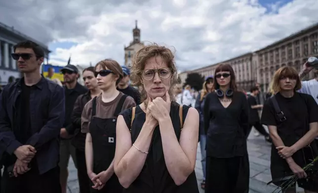 A woman mourns during the farewell ceremony of David Chichkan, a Ukrainian serviceman and artist at Independence square in Kyiv, Ukraine, on Monday, Aug. 18, 2025. (AP Photo/Evgeniy Maloletka)