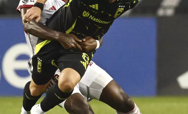 Toronto FC's Deandre Kerr, back, tackles Columbus Crew's Daniel Gazdag during first-half MLS soccer action in Toronto, Saturday, Aug. 16, 2025. (Jon Blacker/The Canadian Press via AP)