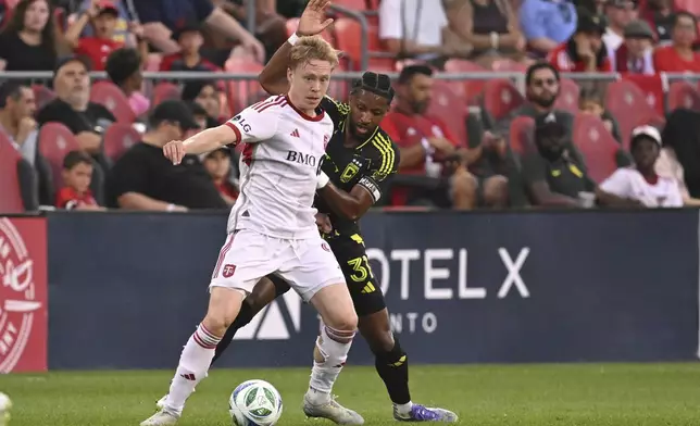 Toronto FC's Ola Brynhildsen, front, defends the ball against Columbus Crew's Steven Moreira during first-half MLS soccer action in Toronto, Saturday, Aug. 16, 2025. (Jon Blacker/The Canadian Press via AP)