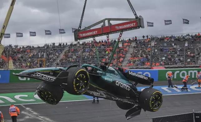 Race marshals remove the car of Aston Martin driver Lance Stroll of Canada after a crash during the second practice for the Formula One Dutch Grand Prix in Zandvoort, Netherlands, Friday, Aug. 29, 2025. (AP Photo/Patrick Post)