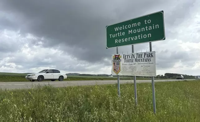 Vehicles pass by the boundary sign for the Turtle Mountain Reservation in northern North Dakota on Wednesday, July 23, 2025. (AP Photo/Jack Dura)