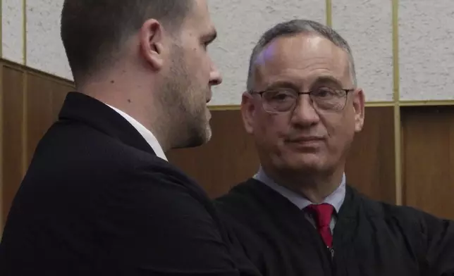Chief Judge Peter Welte, at right, listens to North Dakota Republican Secretary of State Michael Howe, at left, following a naturalization ceremony on Friday, June 27, 2025, at the William L. Guy Federal Building in Bismarck, N.D. (AP Photo/Jack Dura)